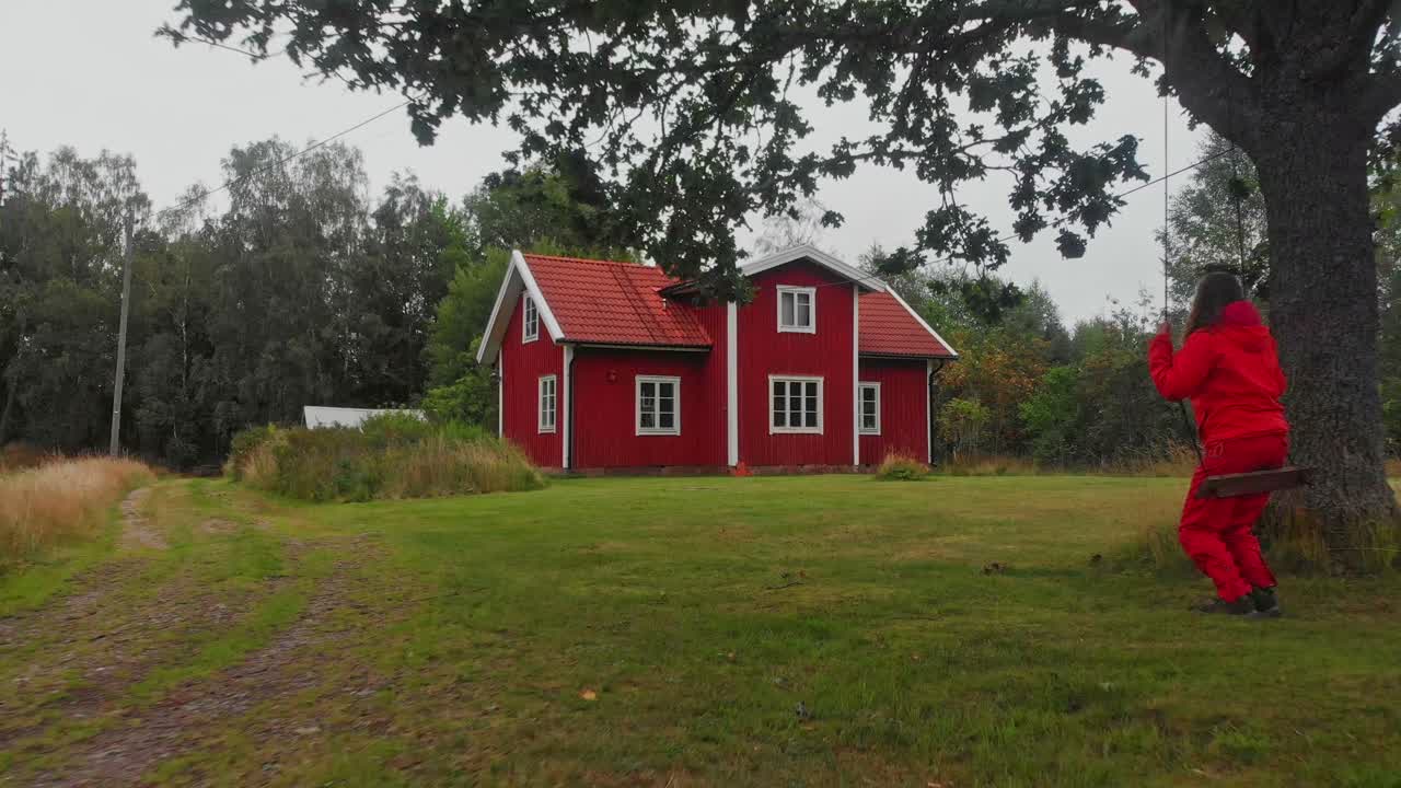 Flygfoto över traditionellt rött trähus omgivet av natur i Ljungby, Kronobergs län, Sverige