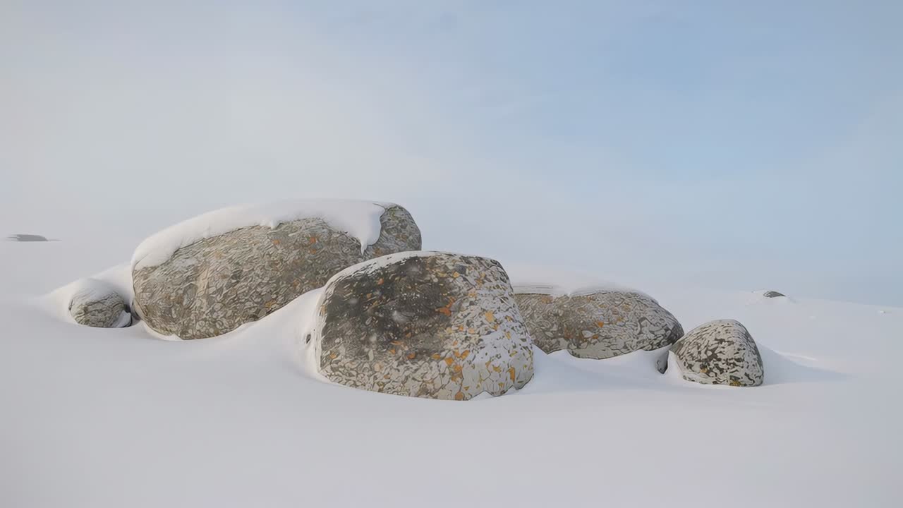 Caméra panoramique capturant un groupe central de rochers enneigés dans une plaine dégagée, enregistrant une lumière subtile