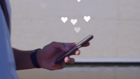 animation of social media reactions over hands of african american man using smartphone