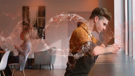 man leaning on counter using smartphone in coffee shop, showing technology data network overlay