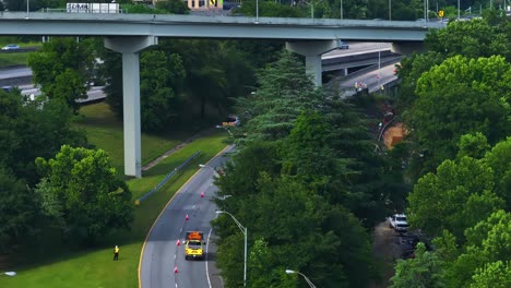 car with led sign board showing lane closed and left arrow sign - traffic redirection due to road works ahead. - wide shot