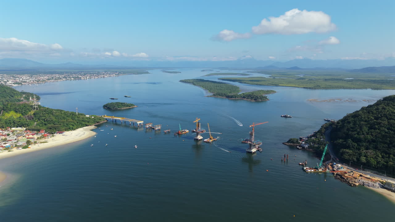 High altitude backward aerial movement from the new Guaratuba-Matinhos Bridge project's construction area, Paraná, Brazil