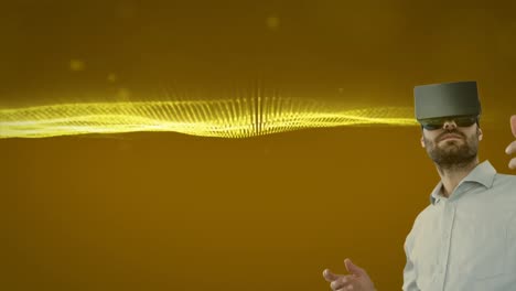 caucasian man wearing vr headset against golden digital waves and light spots on yellow background