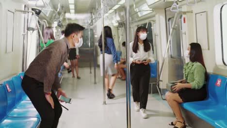 multitud de personas con máscaras faciales en un tren de metro público lleno de gente