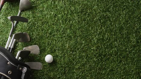 Close-up-of-golf-clubs-and-ball-on-grass,-copy-space,-slow-motion