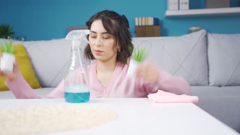 mujer joven limpiando en casa limpiando la mesa polvorienta.