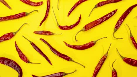 red chile de árbol chilies stop motion movement as pattern on fun vibrant yellow background 4k