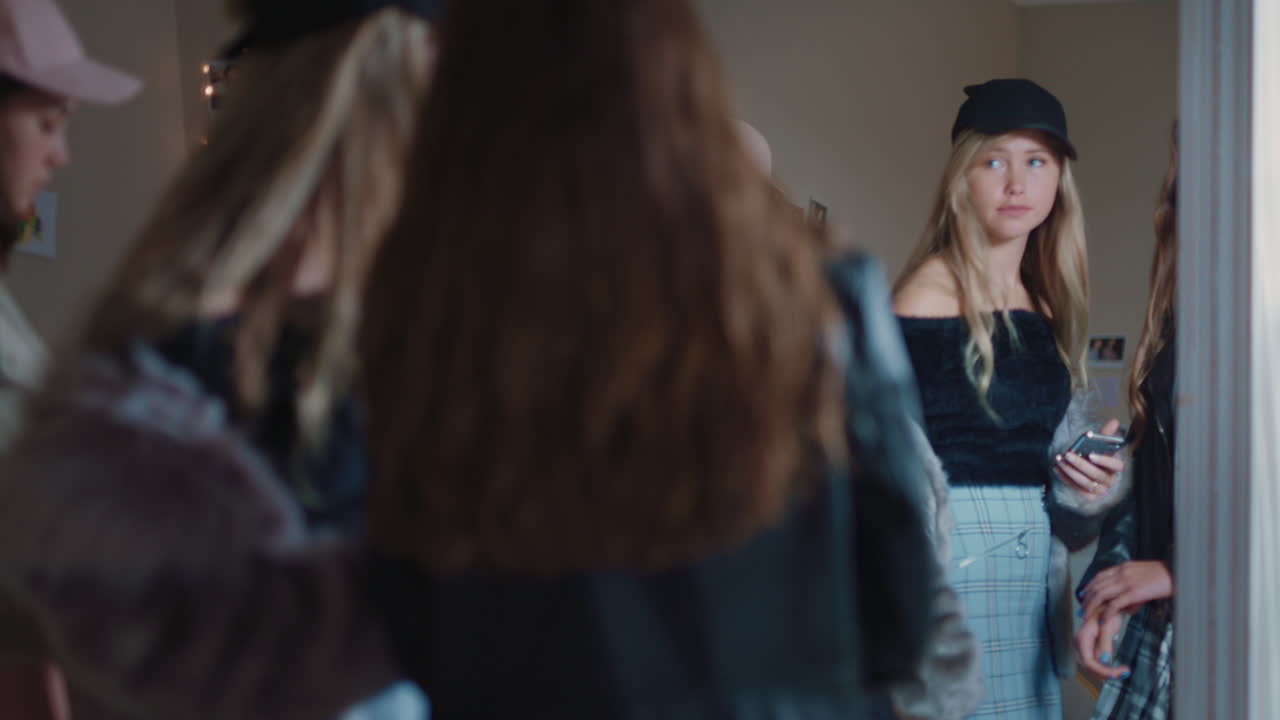 행복한 여자 친구들이 스마트폰을 사용하여 셀카 사진을 찍고 거울에 포즈를 취하고 소셜 미디어에서 세련된 패션을 공유하고 주말을 집에서 즐기며 함께 어울립니다.