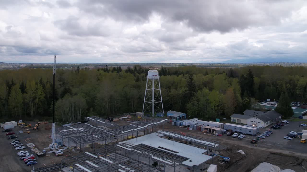 건설 현장 위를 천천히 지나가고, 완전히 확장된 크레인 붐, 하늘을 가로지르는 구름