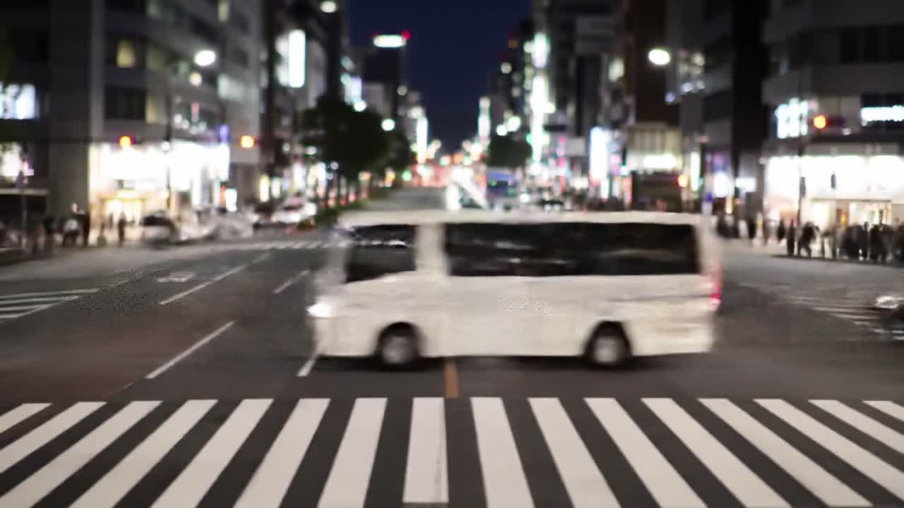 A Vibrant Night Scene of Urban Life Featuring a Yellow Bus and Moving Vehicles on a Busy Intersection with Pedestrians and Bright City Lights
