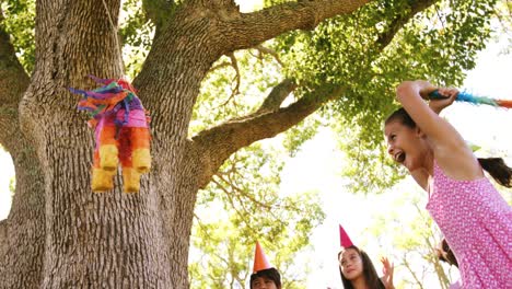 girl hitting a multicolored puppet with stick