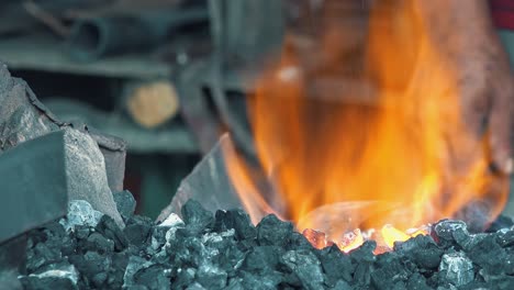 Close-Shot-of-Blacksmith-Stoking-the-Fires-of-the-Forge-for-Metal-Work