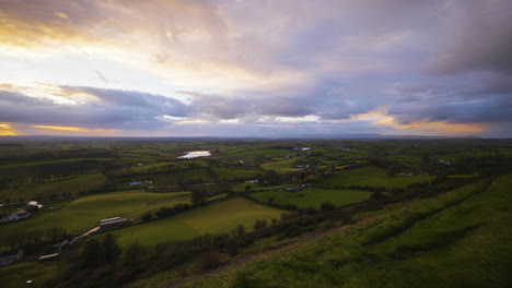 Panorama-Bewegungs-Zeitraffer-Einer-Ländlichen-Agrarlandschaft-Mit-Schafen-Auf-Grasfeldern-Und-Hügeln-Bei-Bewölktem-Sonnenuntergang,-Gesehen-Von-Keash-Caves-In-Der-Grafschaft-Sligo-In-Irland