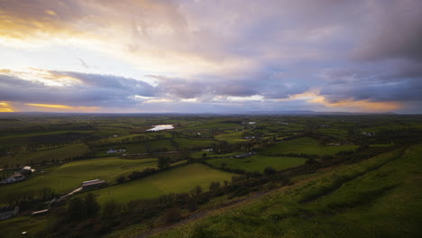 panorama motion time lapse of rural farming landscape with sheep in grass fields and hills during cloudy sunset view from keash caves in county sligo in ireland (愛爾蘭斯萊戈縣的基什洞穴的風景,從雲<unk>的日落時看到草地和山丘上的羊).這是一幅鄉村農業風景的全景.