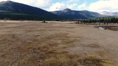 Aerial-drone-shot-straight-to-the-horizon-where-the-mountain-is,-and-then-goes-up-slowly