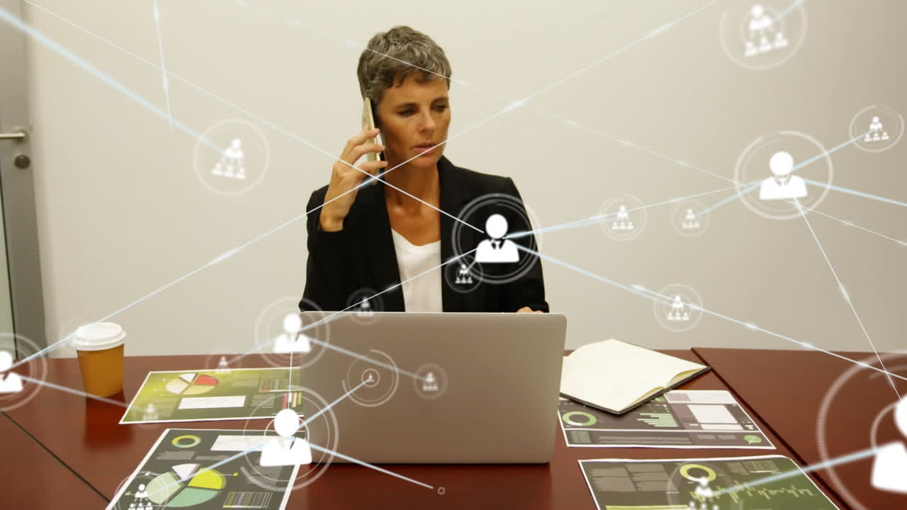 Animation of network of profile icons over caucasian businesswoman talking on smartphone at office