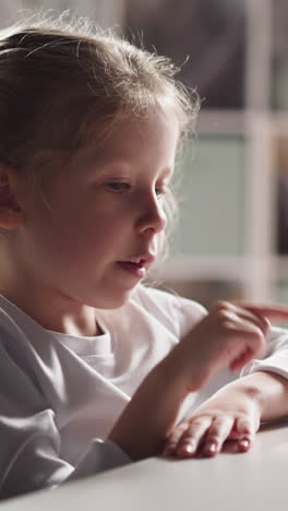 Pretty little schoolgirl with braids counts moving lips aloud plastic sticks solving problem at mental arithmetic lesson at home closeup slow motion