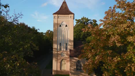 majestic aerial view flight of village church bell tower in paretz raise up drone
in brandenburg havelland germany summer evening 2022