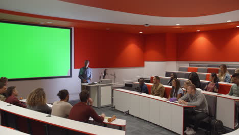 Teacher-at-lectern-listening-to-students-in-lecture-theatre