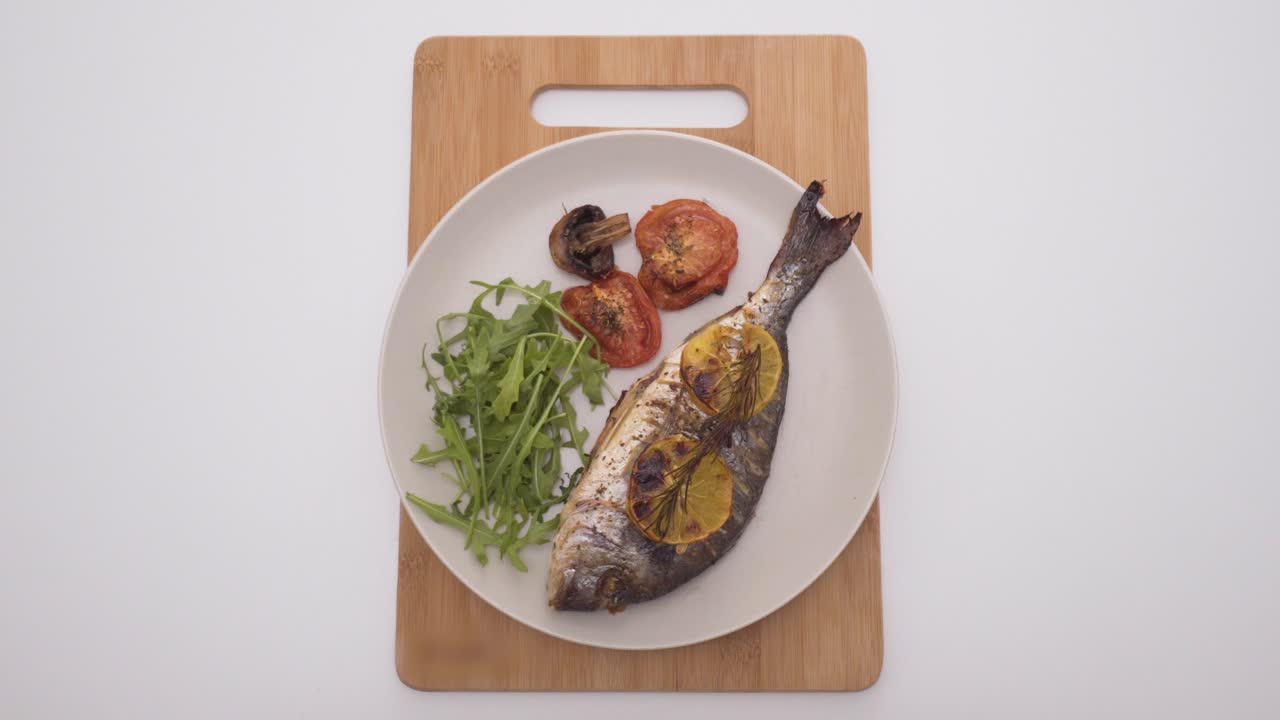 pescado asado con limón, hierbas y verduras