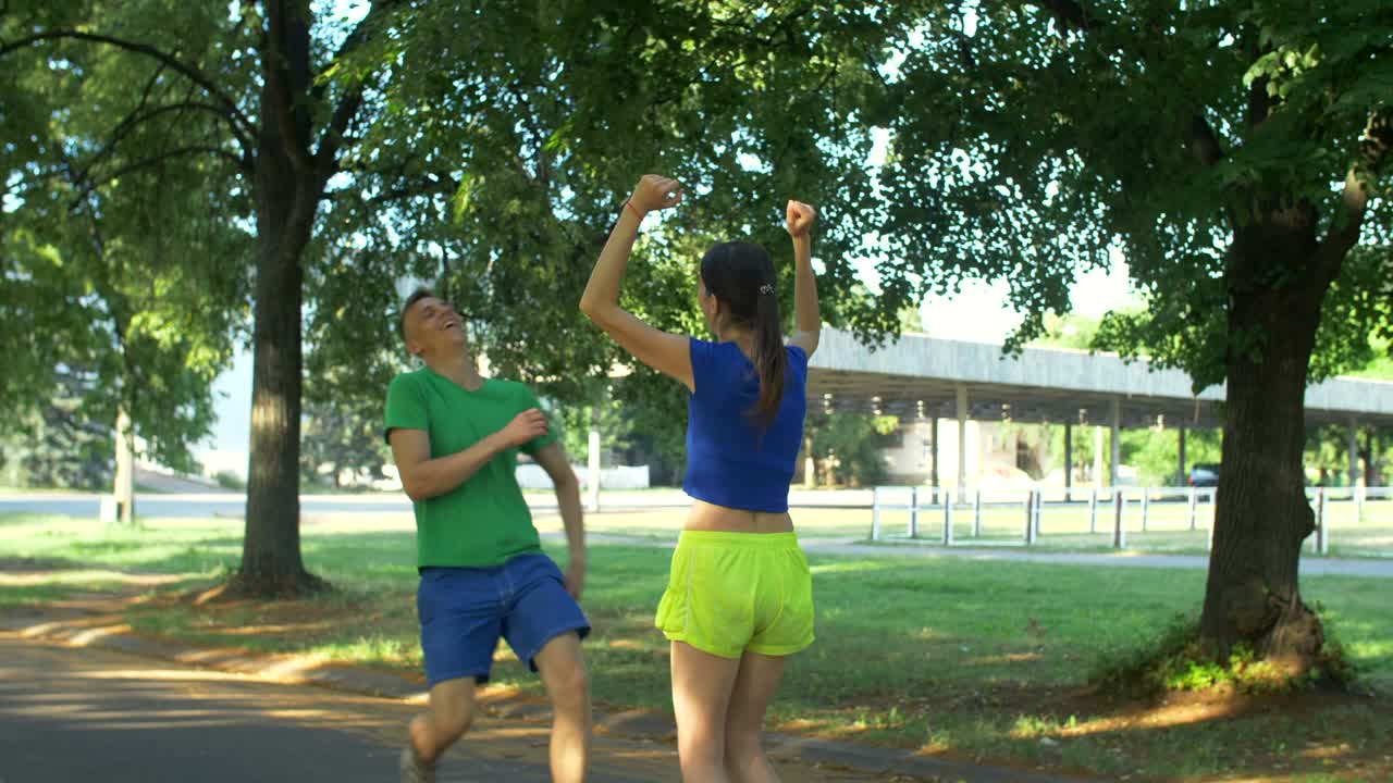 Cheerful fit woman encouraging runner outdoors