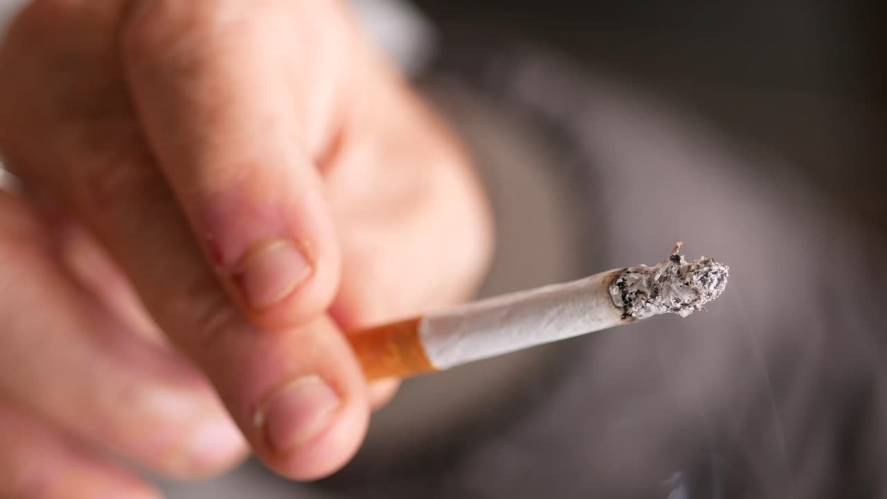 primer plano de una persona fumando un cigarrillo