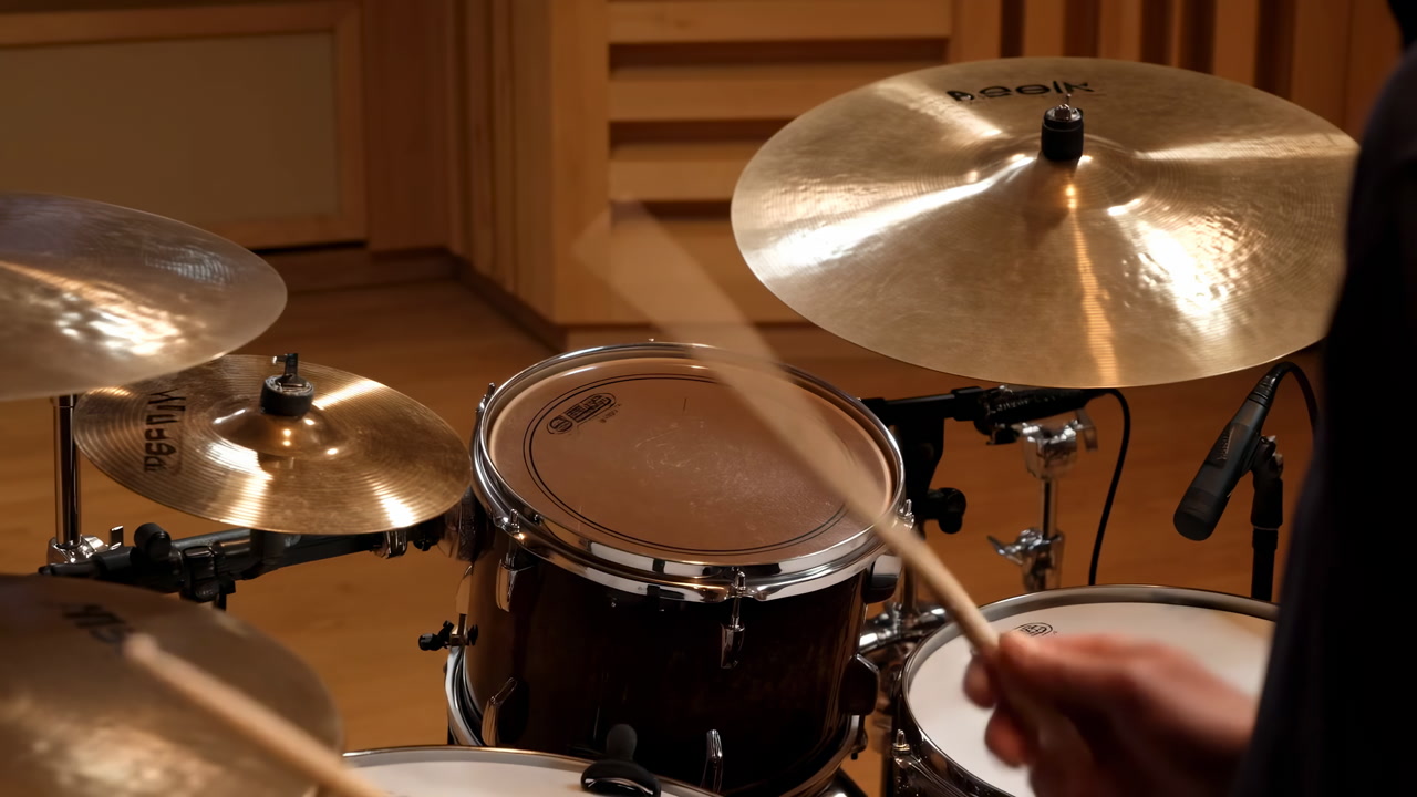 Drum Kit Close Up Showing Hands Striking Snare And Cymbals In Warm Recording Studio, Sticks Blurred
