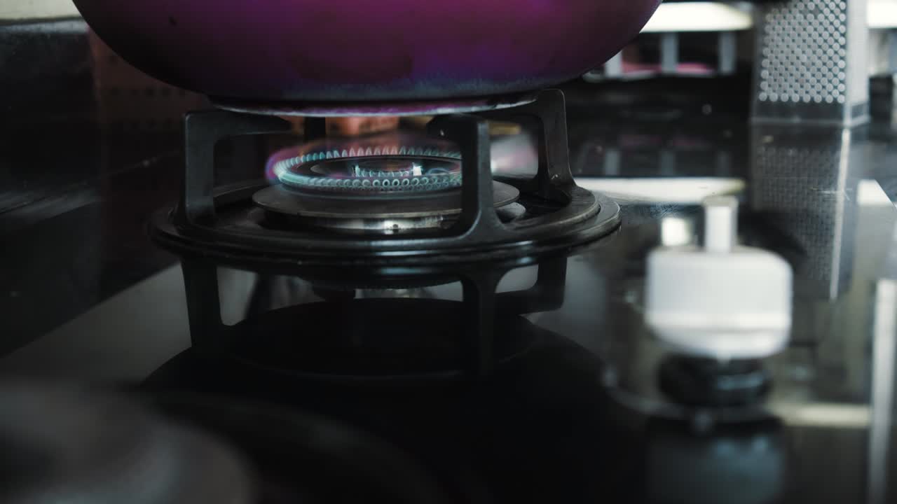 부에서 파란색과 빨간색으로 불타는 불꽃이 있는 검은색 가스 스토브의 비디오
