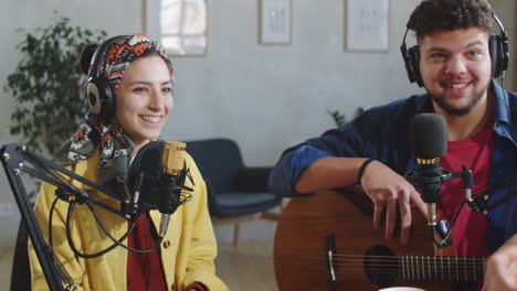 male and female musicians giving podcast interview in studio