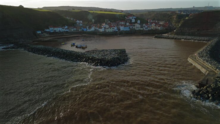 Ripresa aerea introduttiva con drone in avvicinamento al villaggio costiero di Staithes, Yorkshire.