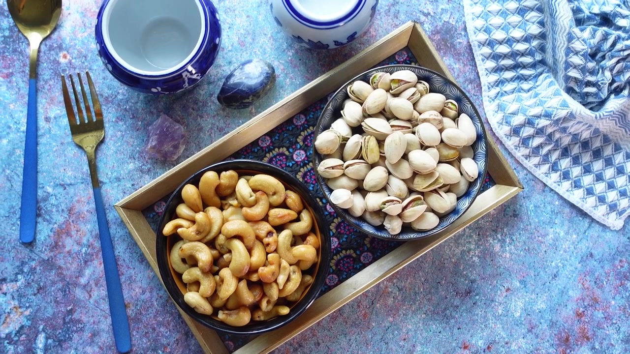 Ciotole di anacardi e pistacchi su un vassoio decorativo
