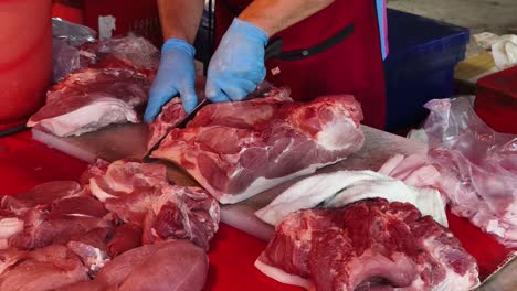 butcher cutting pork at market