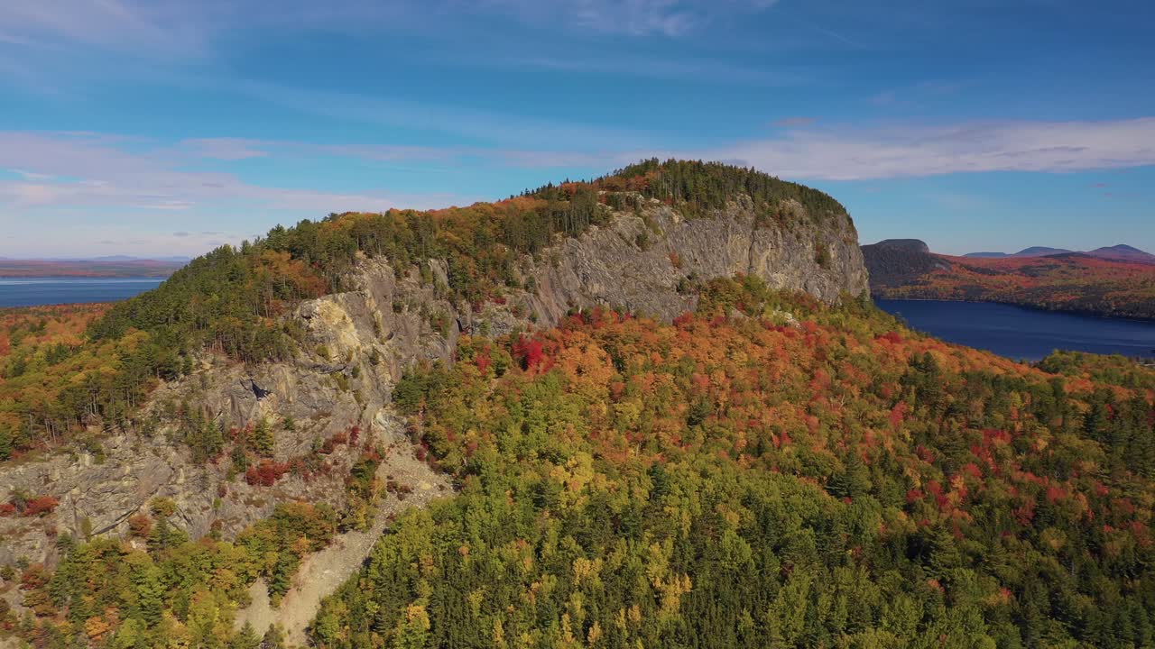 órbita aérea hacia la montaña kineo en el pico del follaje de otoño