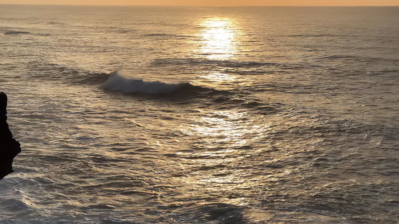 ondas oceánicas en movimiento lento al atardecer rodando y rompiendo con la luz de fondo