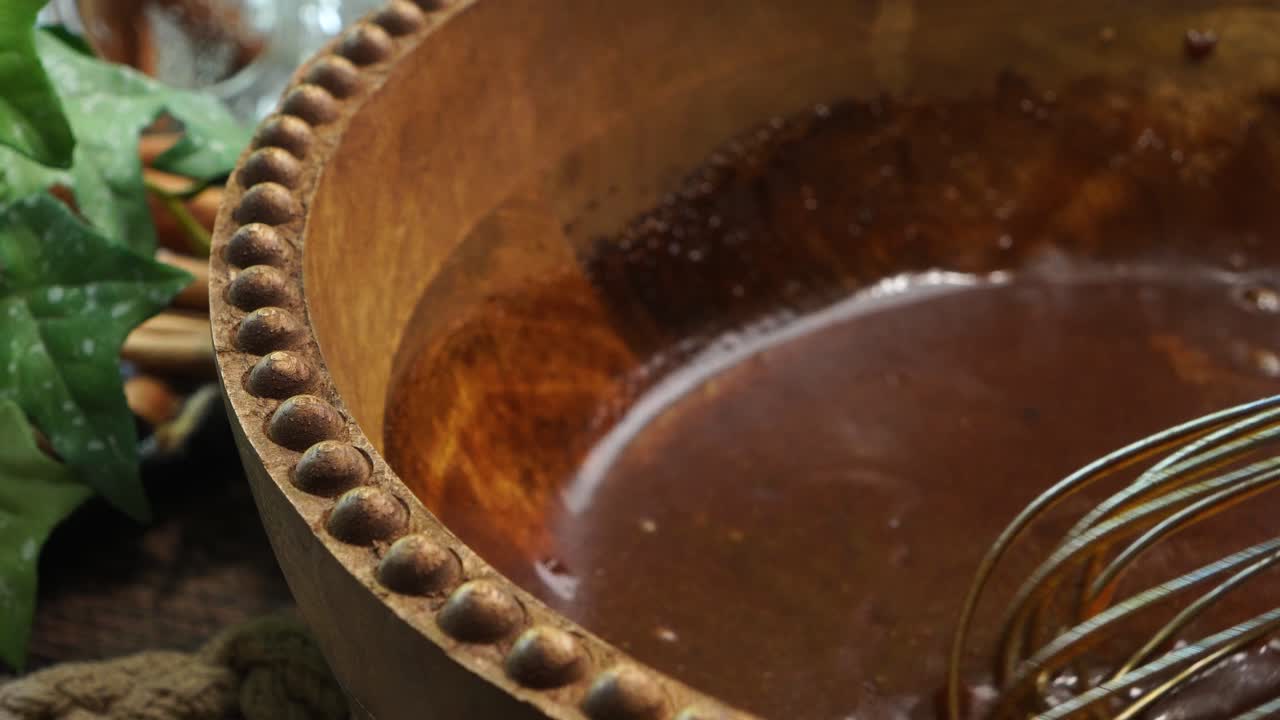 Baking a carrot cake loaf with cream cheese icing and topped with roasted salted pecans. Making a Autumn dessert with carrots, flour, sugar, nuts and frosting. Mixing and whisking carrot cake batter.