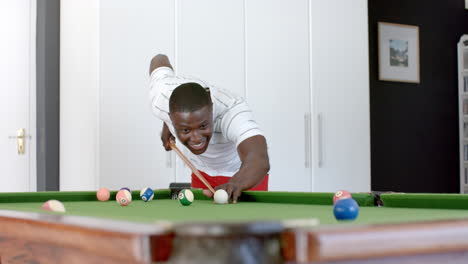 young african american man playing pool at home