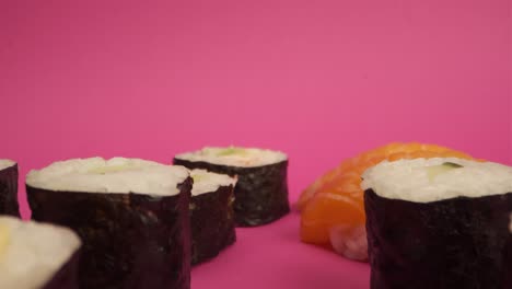 fotografía de estudio de rollos de sushi en fondo rosa