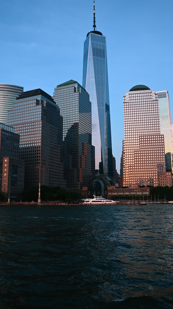 Yacht ormeggiato sul lungomare di New York, USA. Vista dal basso angolo dei grattacieli di vetro di Manhattan dal paesaggio fluviale. Video verticale