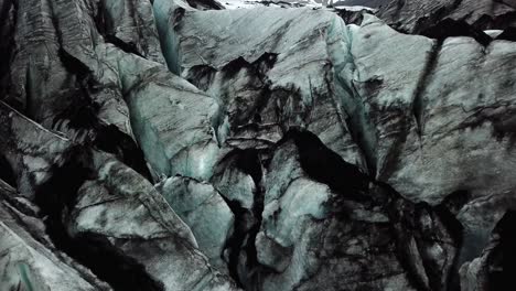 vista aérea del hielo texturizado del glaciar sólheimajökull, islandia, en verano