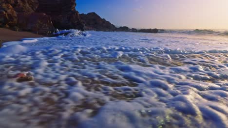 toma en cámara lenta de las olas del mar rompiendo en la playa de arena