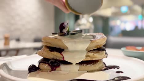 delicious stack of pancakes with blueberry sauce and whipped cream