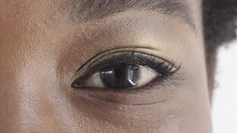 Nahaufnahme-Eines-Schwarzen-Frauenauges-Mit-Make-up,-Das-Glücklich-In-Die-Kamera-Schaut,-Blinzelnde-Schönheit,-Kosmetik,-Weißer-Hintergrund