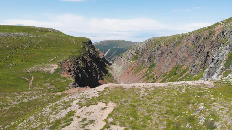 Spettacolare paesaggio naturale, ripresa con carrello all'indietro che cattura il canyon di Dromskåran e i paesaggi montuosi nella Riserva Naturale di Bastudalen, Jämtland, Svezia, in pieno giorno