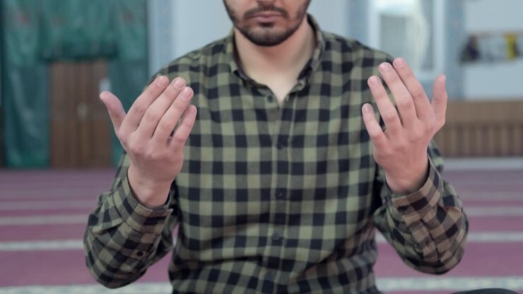 Man Holds Hands Up During Prayer In Mosque