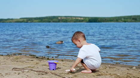 toddler playing in the sand at the lake
