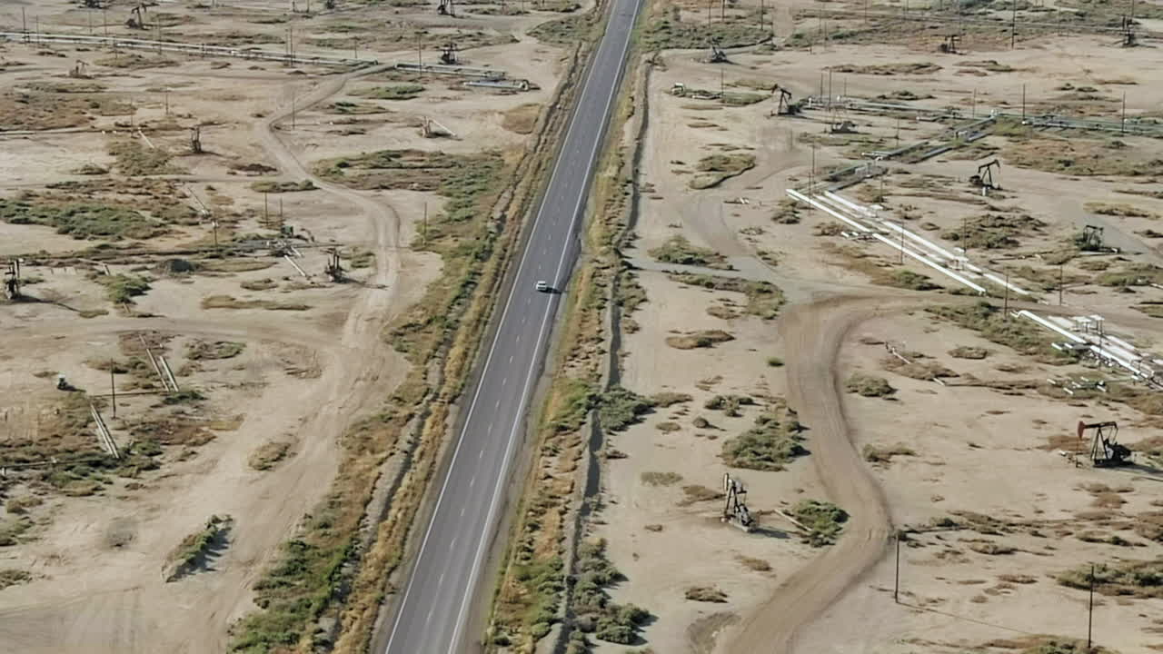 황폐 한 풍경 에서 석유  ⁇  과 정제 공장 으로 운전 하는 차량 - 공중