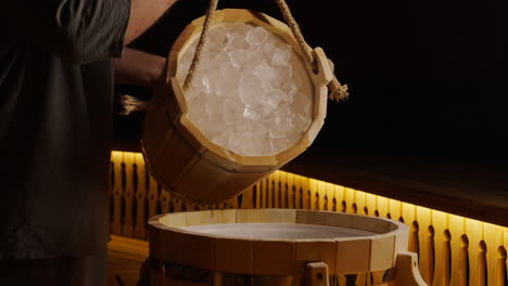 pouring ice cubes into sauna