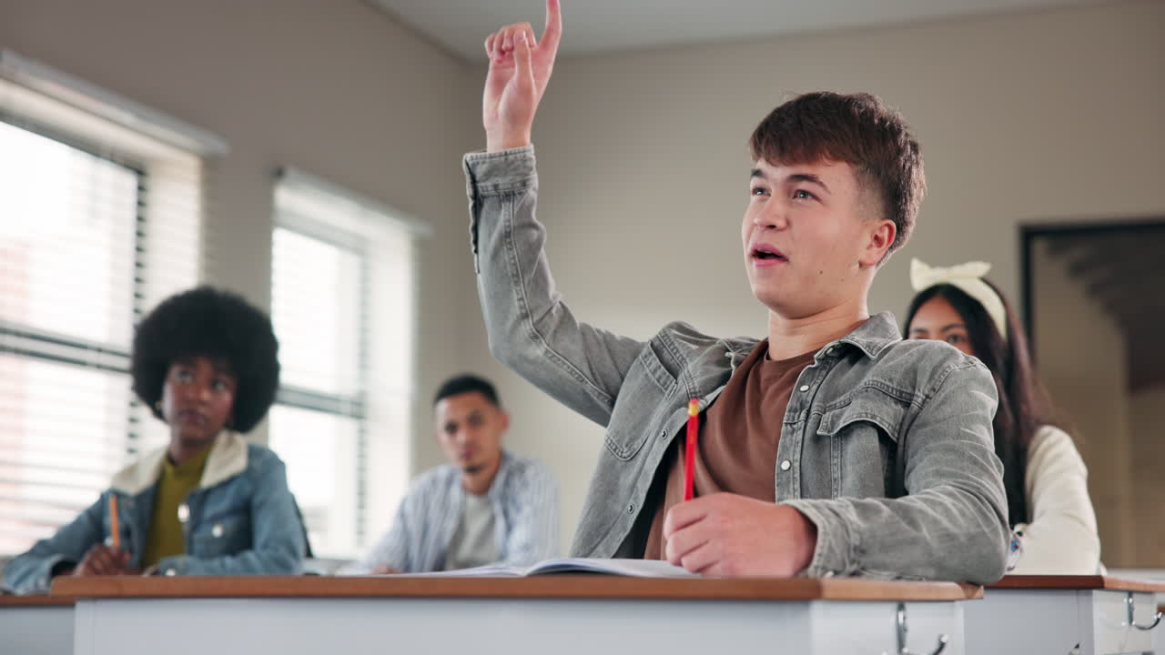 Students in a classroom learning and raising hands