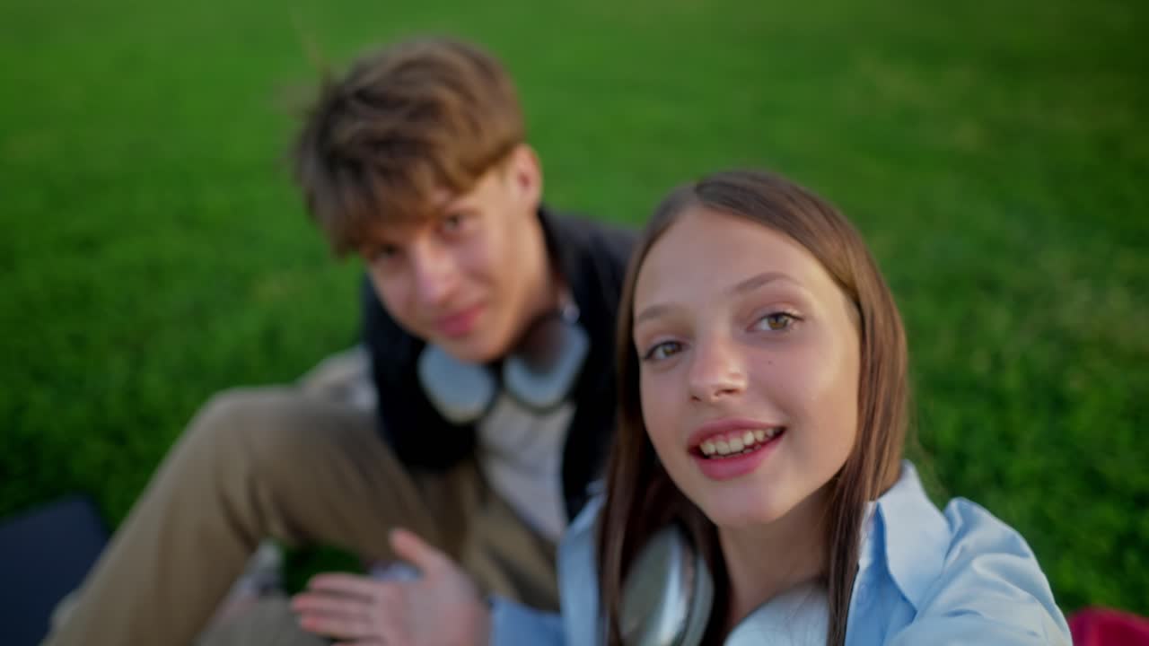 Teini-ikäinen tyttö ja poika ottamassa selfietä yhdessä