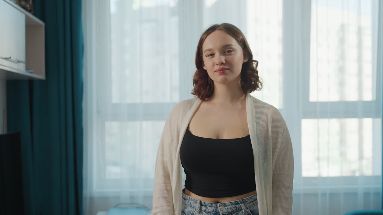 Soft Window Portrait Of Caucasian Woman Showing Smile And Calm Expression, Natural Light Fills Apartment Interior With Curtains And Gentle Bokeh, Relaxed Posture And Authentic Lifestyle Vibe